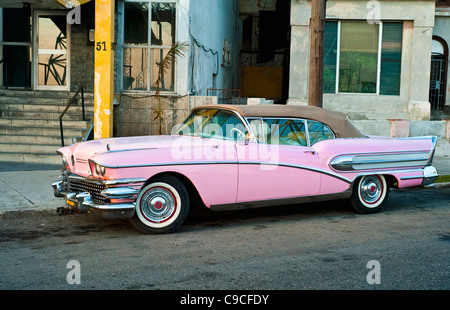 Cuba, Caribbean, Havana, Pink vintage Buick convertible car with the roof raised parked in street. Stock Photo