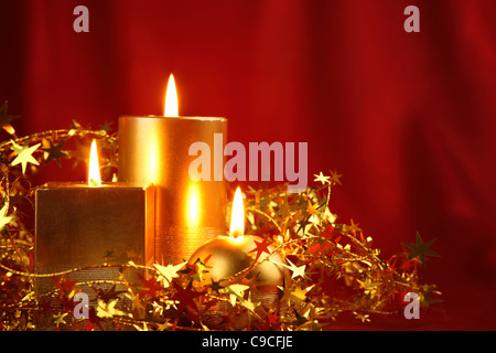 Burning candles in a Christmas setting with seasonal decorations. Stock Photo