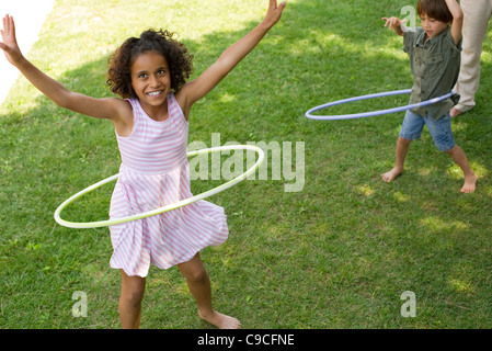 Children playing with plastic hoop outdoors Stock Photo
