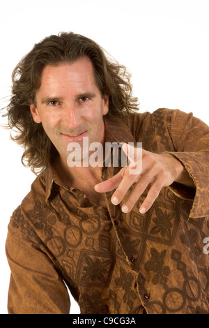 Handsome male points his finger to viewer and smiles Stock Photo