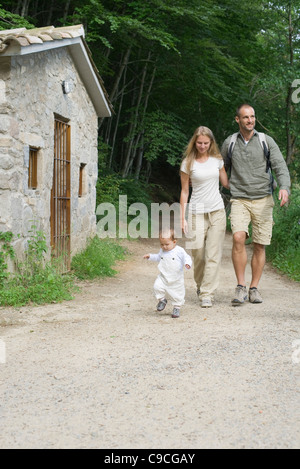 Parents hiking in woods with toddler Stock Photo