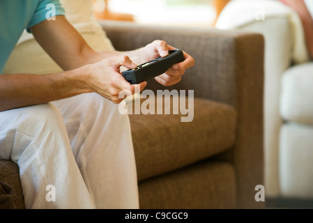 Man playing video game using wireless controller, cropped Stock Photo