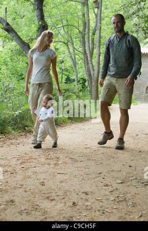 Parents hiking in woods with toddler Stock Photo