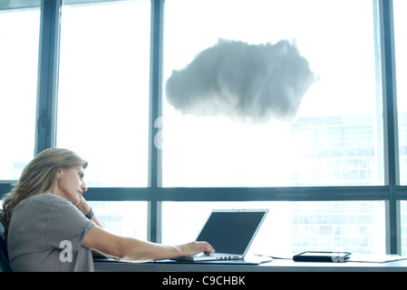 Woman using laptop computer. cloud above laptop computer Stock Photo