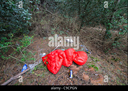 discarded sleeping bag with beer cans and pizza box Stock Photo