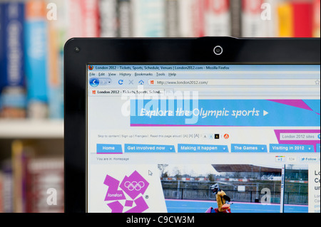 The London 2012 website shot against a bookcase background (Editorial use only: print, TV, e-book and editorial website). Stock Photo