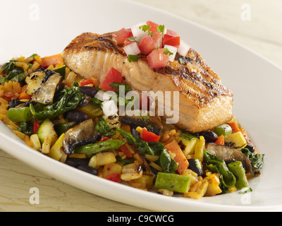 Grilled salmon fillet topped with salsa fresca and served over grilled vegetables and rice Stock Photo