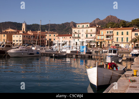 Travel, Italy - Old fisherman cleaning fishnets in his boat - Porto Azzurro, Eba Island, Italy. Stock Photo