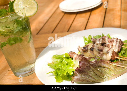 Fine Dining in a Tropical Resort.  A Mojito and Chicken Satay in Kauai Hawaii Stock Photo