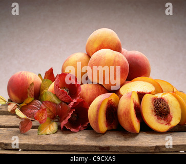 Yellow freestone peaches whole and halved showing stone. Stock Photo