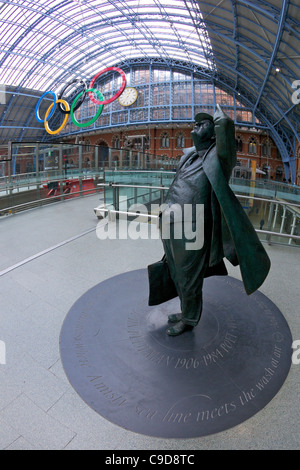 Statue of Sir John Betjeman in front of the Olympic Rings Logo, in the Eurostar terminal at Kings Cross St Pancras Railway Stati