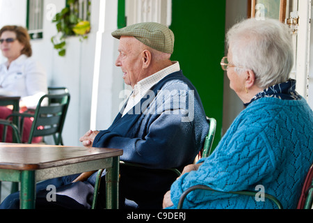 Elderly couple sitting outside at table, Tarifa, Costa de la Luz, Andalucia, Spain Stock Photo