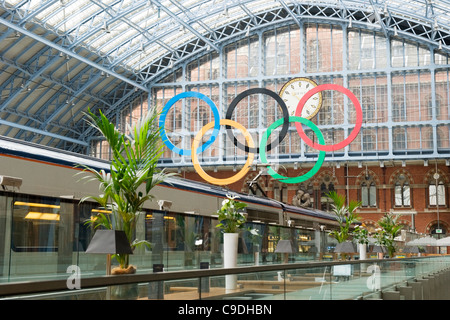 London St Pancras Station the Olympic rings from Champagne Bar Eurostar train in foreground glass roof roofs small palm trees stools Dent clock
