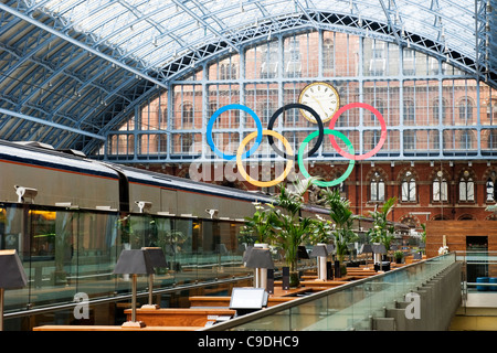 London St Pancras Station the Olympic rings from Champagne Bar Eurostar train in foreground glass roof roofs small palm trees stools Dent clock