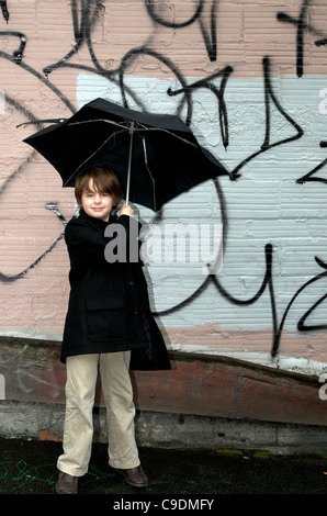 Boy with umbrella in the city Stock Photo