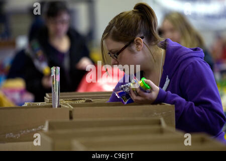 London Ontario, Canada - December 8, 2011. Katie Hart sorts through boxes of donated toys that will go into Christmas toy hampers at the 2011 Salvation Army toy and food drive distribution centre inside the Progress Building at the Western Fair District. This year the Salvation Army expects to provi Stock Photo