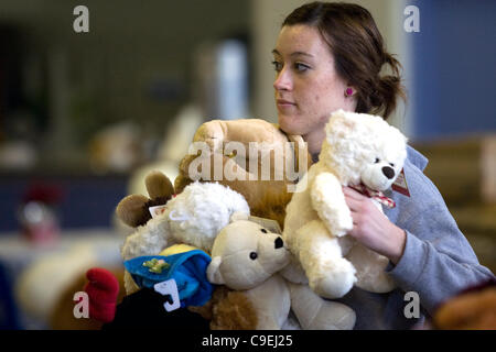 London Ontario, Canada - December 8, 2011. Melanie Dryburgh collects an arm full of stuffed animals that will go into Christmas toy hampers at the 2011 Salvation Army toy and food drive distribution centre inside the Progress Building at the Western Fair District. This year the Salvation Army expect Stock Photo