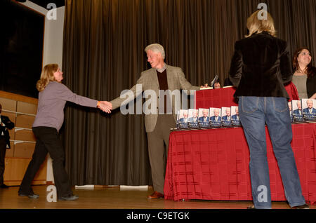 President Bill Clinton shakes hands and signs copies of his new book Back to Work at his hometown library in Chappaqua, New York. More than 500 people attended the booksigning on Friday, December 9, 2011. Stock Photo