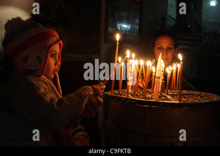 Dec. 16, 2011 - Bethlehem, West Bank, Palestinian Territory - A Palestinian girl lights a candle in the Church of the Nativity, the site revered as the birthplace of Jesus, in the West Bank town of Bethlehem December 15, 2011, ahead of Christmas. Christian worshippers began their spiritual preparati Stock Photo