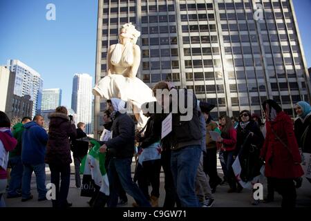 Chicago, USA, 29/12/2011. Protesters march past Marilyn Monroe Statue in Pioneer Court during anti-Syrian government protest. The demonstrators gathered to protest the Syrian government's treatment of its citizens. Stock Photo