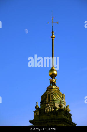 As the sun comes out in Brighton this afternoon the moon can be seen rising in a clear blue sky behind the clock tower  Photograph taken by Simon Dack 3 January 2012 Stock Photo