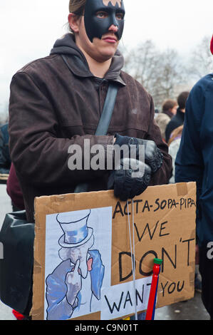 Anonymous Protest Against Internet Anti-Piracy Law, ACTA (Anti-Counterfeiting Trade Agreement), a bill that threatens freedom of the Internet, Paris, France, Man Holding Protest Sign 'We Don't Want' protest free-trade Stock Photo