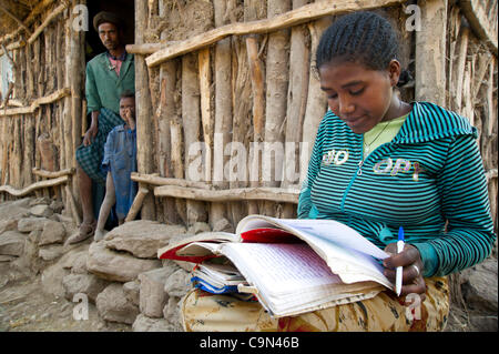 Jan. 16, 2012 - Farta (Woreda, South Gondar (Zone, Ethiopia - January 16, 2012, Ayva Niva, Ethiopia - A TESFA pilot project participant uses the late afternoon light to study her civics lessons outside of her family home in Ayva Niva, Ethiopia. This young woman took part in the control group of the  Stock Photo