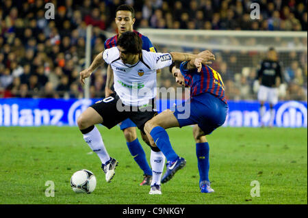 01/02/2011 - VALENCIA, Spain // COPA DEL REY FOOTBALL - Soccer - Valencia CF vs. FC Barcelona - 1/2 finals - Estadio Mestalla ----------- Ever Banega from Valencia CF trying to dribble Busquets and Thiago Stock Photo