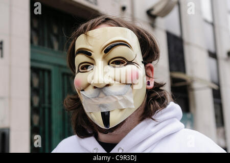 Member of the hacker group 'anonymous' wearing a 'V for Vendetta' mask and tape over the mouth signifying censorship and curtailment of freedom of speech Stock Photo