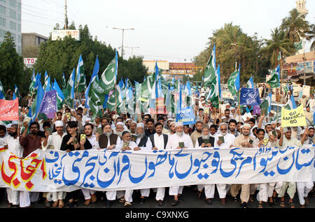 Leader and supporters of Jamat-e-Islami (JI) pass through University road during protest rally against desecration of the Holy Quran by US soldiers in Afghanistan, in Karachi on Friday, March 02, 2012. Stock Photo