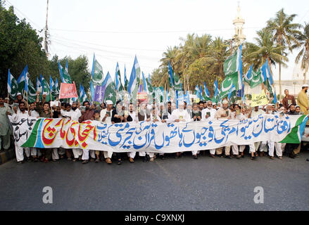 Leader and supporters of Jamat-e-Islami (JI) pass through University road during protest rally against desecration of the Holy Quran by US soldiers in Afghanistan, in Karachi on Friday, March 02, 2012. Stock Photo