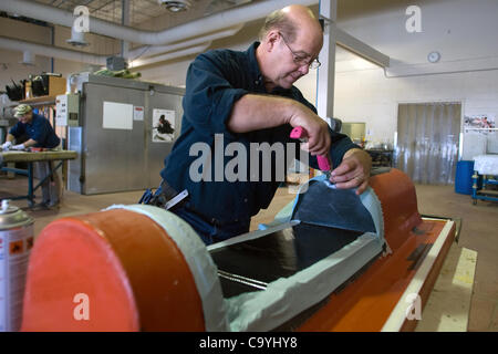 London Ontario, Canada - March 5, 2012. Dan McCutcheon lays fabric material used in the building process of each racing skull. Stock Photo