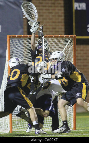 March 10, 2012 - Rock Island, Iowa, U.S. - Augustana's Colin Haley shoots and scores (bottom left corner) as he collides with Fontbonne's Colin Benecke (20) and Mike Liebreich in front of the goal Friday, March 9, 2012, during first-half action on Thorson-Lucken Field in Rock Island. Fontbonne goali Stock Photo