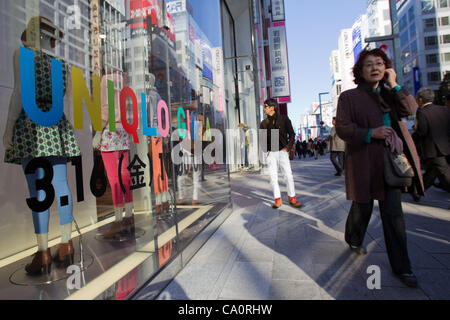 March 15, 2012, Tokyo, Japan - Pedestrians walk past the new Uniqlo store in downtown Tokyo. Fast Retailing's Uniqlo brand will open its world's largest flagship store to date on March 16 in the Ginza shopping district of Tokyo. This new megastore will consist of 12 floors offering various types of  Stock Photo