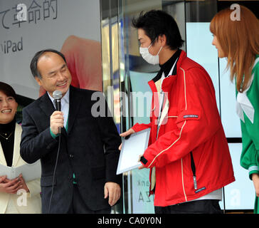 March 16, 2012, Tokyo, Japan - President Masayoshi Son, left, of Japans Softbank, congratulates the first customer on getting the New iPad as the Apples retailer kicks off the release of its third-generation tablet computer at its flagship store in Tokyos Ginza shopping district on Friday, March 16, Stock Photo
