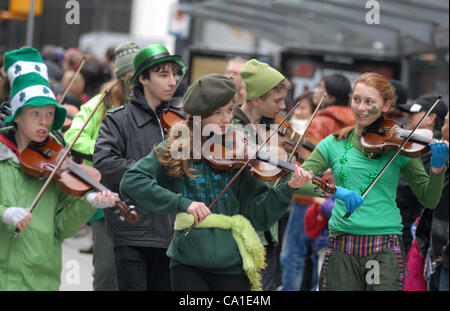 Young fiddlers entertain public at the annual St. Patrick's Day Parade in Vancouver, March 18, 2012. Thousands of people have crowded downtown Vancouver to watch as bagpipers, Irish dancers and hurlers paraded with dreadlocked dancers, green samba queens, and even a roller derby team took part in th Stock Photo