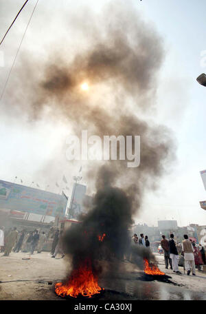 Supporters of Hazara Democratic Party (HDP) gather near burning tyres as they are protesting against target-killing of Hazara community in Quetta on Thursday, March 29, 2012. Atleast six people including a woman were killed in terrorists attack on Thursday, a vehicle was on Stock Photo