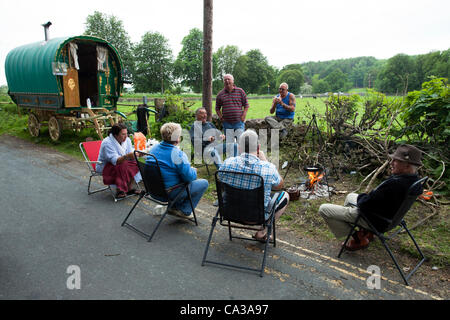 30th May 2012. Cumbria, UK. Several people from the Travelling community sit around a camp fire cooking breakfast at camp site in Kirkby Lonsdale. Traveller’s are assembling for the Appleby Horse Fair held in June. Stock Photo