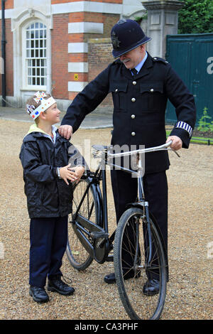 02 June 2012. Hampton Court, England, UK. The Jubilee Garden Party at Hampton Court Palace with 1950's 'Policeman' and boy wearing crown. Stock Photo