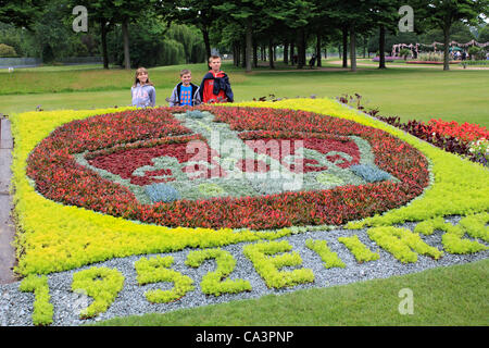 02 June 2012. Hampton Court, England, UK. The Jubilee Garden Party at Hampton Court Palace with children in front of floral crown tribute. Stock Photo