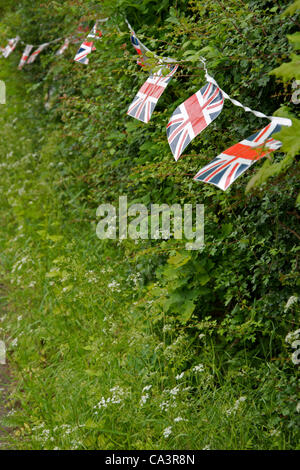 Union Jack bunting decorates the hedge for the village fete. Stock Photo