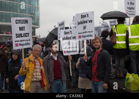 London, UK. 3rd June 2012 Members of the republic group hold up signs and pose for the camera whilst protesting outside the city hall. Around 100 protestors from the Group Republic gathered on the banks of the Thames to protest against the monarchy on the day of the Thames Diamond Jubilee pageant. Stock Photo