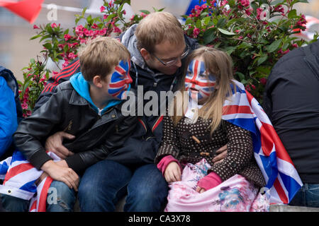 Queens Diamond Jubilee 2012, Revellers in Blackfriars London, children with union jacks painted on there faces embrace in cold weather Stock Photo