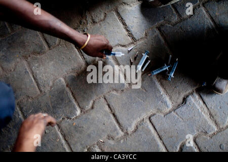 May 16, 2012 - New Delhi, India - A drug addict places his used needle on the ground in order to receive a new one from NGO outreach workers in the Yamuna Bazaar. Approximately 1,200 drug addicts live on the streets in the bazaar, an area that is approximately two kilometers by two kilometers..(Cred Stock Photo