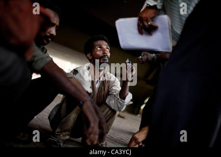 May 16, 2012 - New Delhi, India - A drug addict waits for Sharan outreach workers to give him a clean needle under a bridge in the Yamuna Bazaar, holding the one he used the day before in his hand. Approximately 1,200 drug addicts live on the streets in the bazaar, an area that is approximately two  Stock Photo