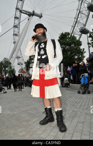 3rd June 2012. Southbank, London, UK. With The London Eye in the background a man in a kilt is enjoying the Pageant on the Thames. Stock Photo