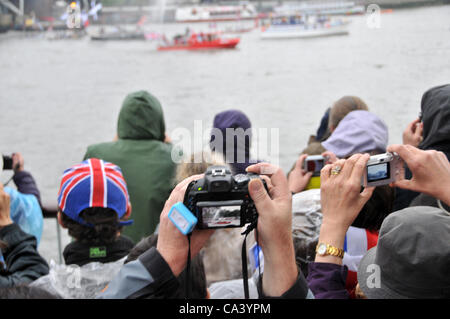 3rd June 2012. Southbank, London, UK. Crowds of people enjoying the Pageant on the Thames and try to photograph the boats as they pass down the river. Stock Photo