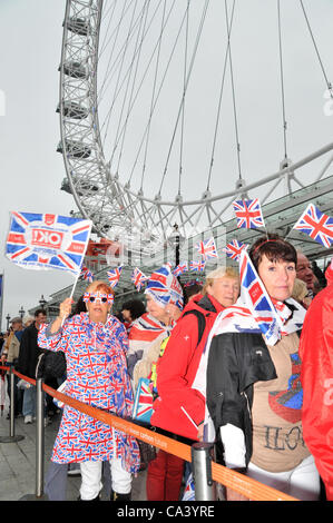 3rd June 2012. Southbank, London, UK. Crowds of people dressed in Union Jack outfits queue for the London Eye as they  enjoy the Pageant on the Thames. Stock Photo