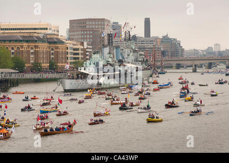 Numerous small boats proceed along River Thames past HMS Belfast as part of the Queen’s Thames Diamond Jubilee Pageant, taken from Tower Bridge, London, UK, 3rd June 2012. The Diamond Jubilee celebrates Queen Elizabeth the second’s 60 years as Head of the Commonwealth. Stock Photo