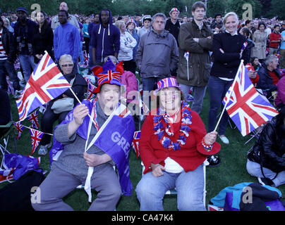 London, UK. June 4, 2012. Two patriotic fans make them selves comfortables as they enjoy celebrating The Queen's Diamond Jubilee and watch the concert on the big screen in St. James's Park, London. Stock Photo